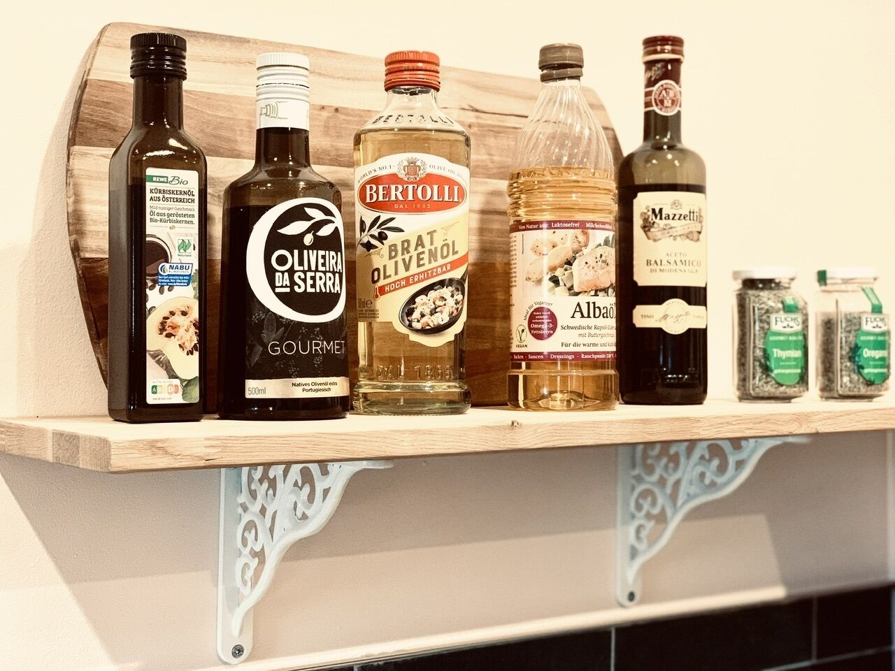 En hylla med olika flaskor olivolja och andra vätskor.