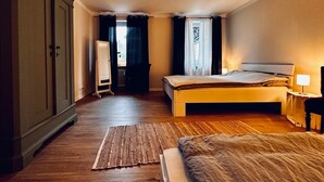 Une chambre à coucher comprenant un lit, une table de chevet, une lampe, une armoire et donnant sur l’extérieur.