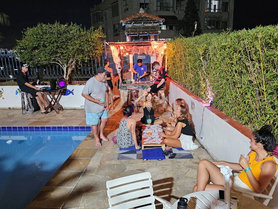 An outdoor pool area with a dining setup and a building in the background.