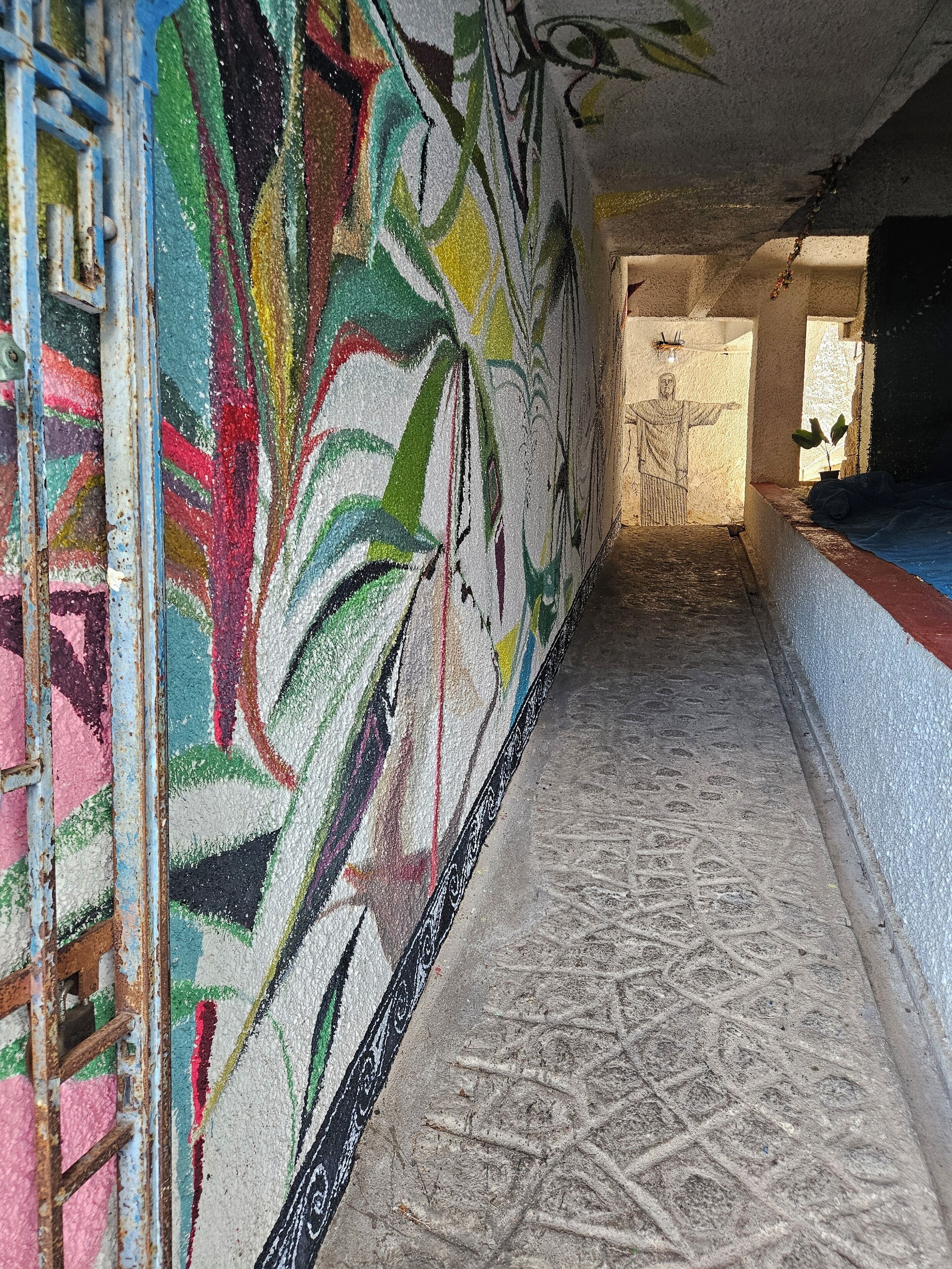 A corridor with colorful graffiti on the walls and a patterned floor.
