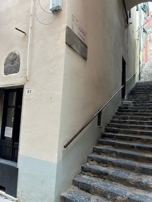 Una escalera estrecha que conduce a una puerta con el número 80.