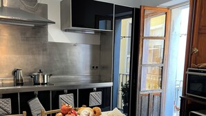 Una cucina moderna con elettrodomestici in acciaio inossidabile, un tavolo da pranzo apparecchiato per la colazione e una vista all'esterno attraverso una finestra.
