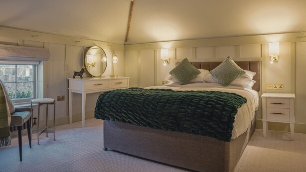 A bedroom with a large bed, bedside tables, a dresser, a mirror, and a window. - The Crown Inn at Burnham Beeches (Slough)