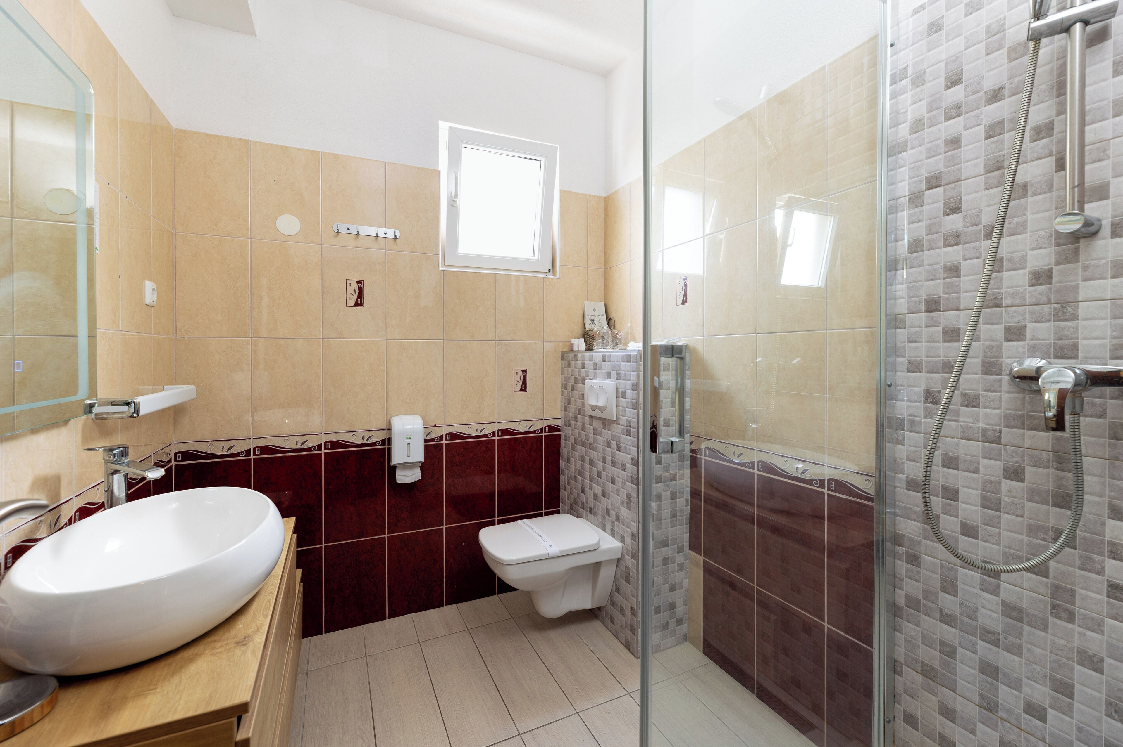 A bathroom with a large oval sink, a toilet, and a glass-enclosed shower area.