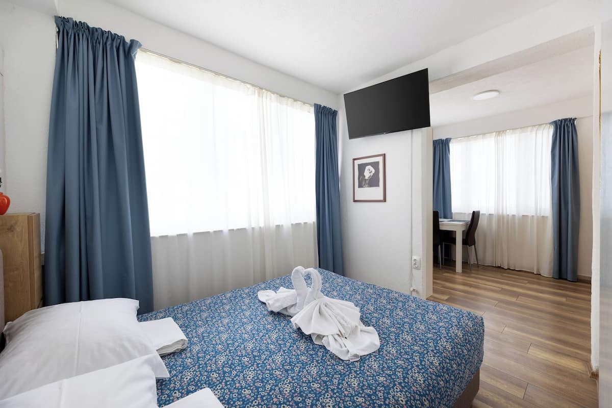 A hotel room with a bed, a desk, and a chair.