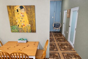 A dining area with a wooden table and chairs, a painting on the wall, and a patterned floor. - Salo-Casa Verde 2nd floor by Stay Here PR (San Juan)