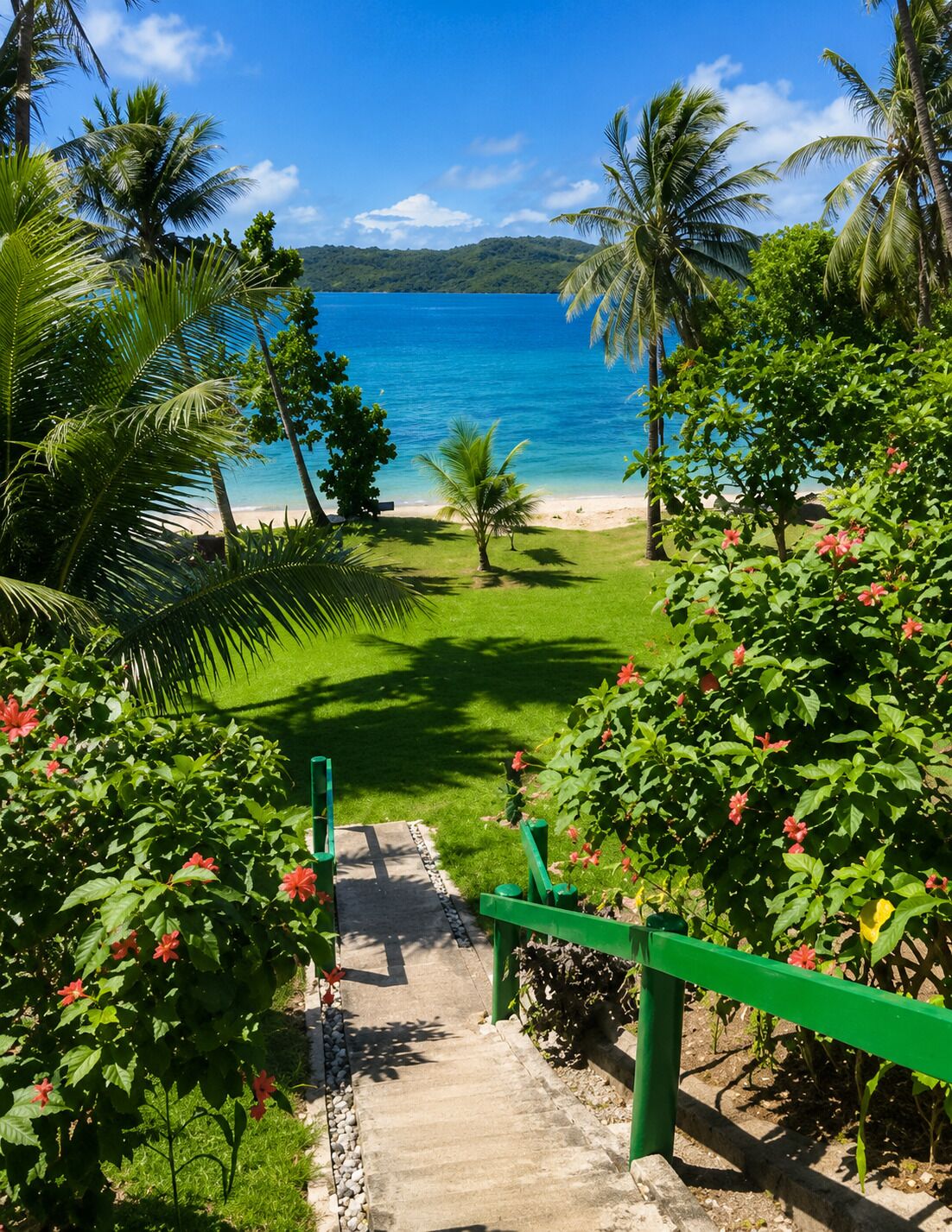 A pathway leading to a beach with palm trees and a view of the ocean.