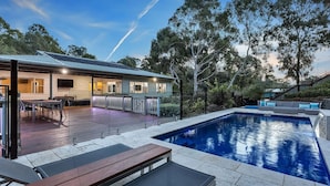A modern house with a swimming pool, outdoor seating, and a deck. - Resort Style Apartment Escape with Heated Pool, Tennis Court Outdoor BBQ (Bellevue Heights)
