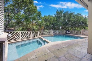 A rectangular swimming pool with a tiled deck, surrounded by a wooden fence and lush greenery. - IOP Home, Ocean and Intracoastal Views! Private Pool and widow's walk balcony! (Isle Of Palms)