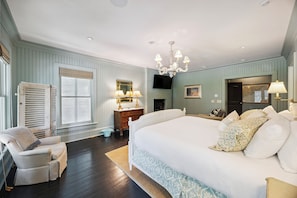 A bedroom with a large bed, a chair, a dresser, a TV, and a chandelier. - IOP Home, Ocean and Intracoastal Views! Private Pool and widow's walk balcony! (Isle Of Palms)