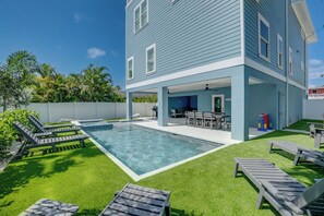 A two-story house with a swimming pool, outdoor seating, and a covered patio area. - Endless Summer (Bradenton Beach)