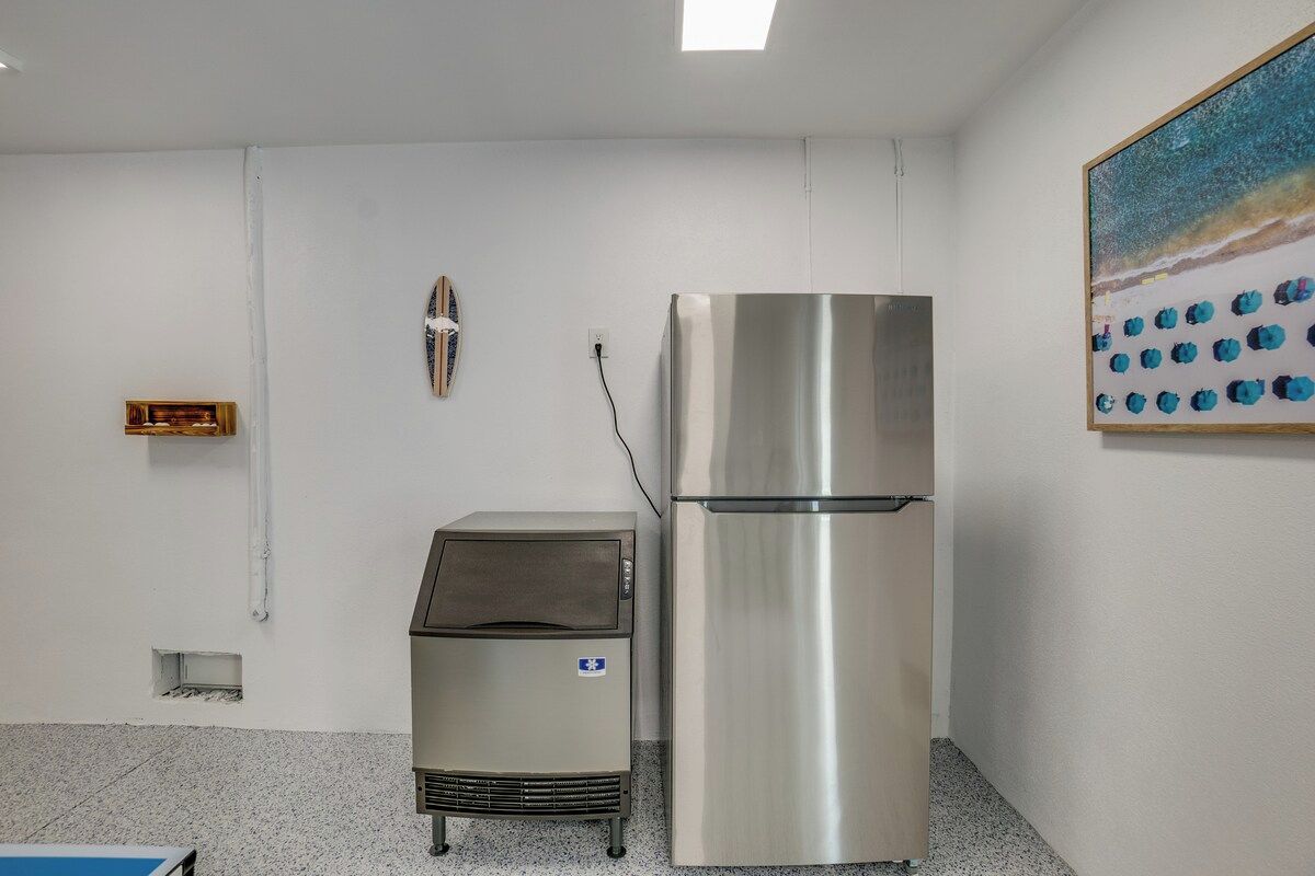A kitchenette with a stainless steel refrigerator, a microwave, and a small oven.
