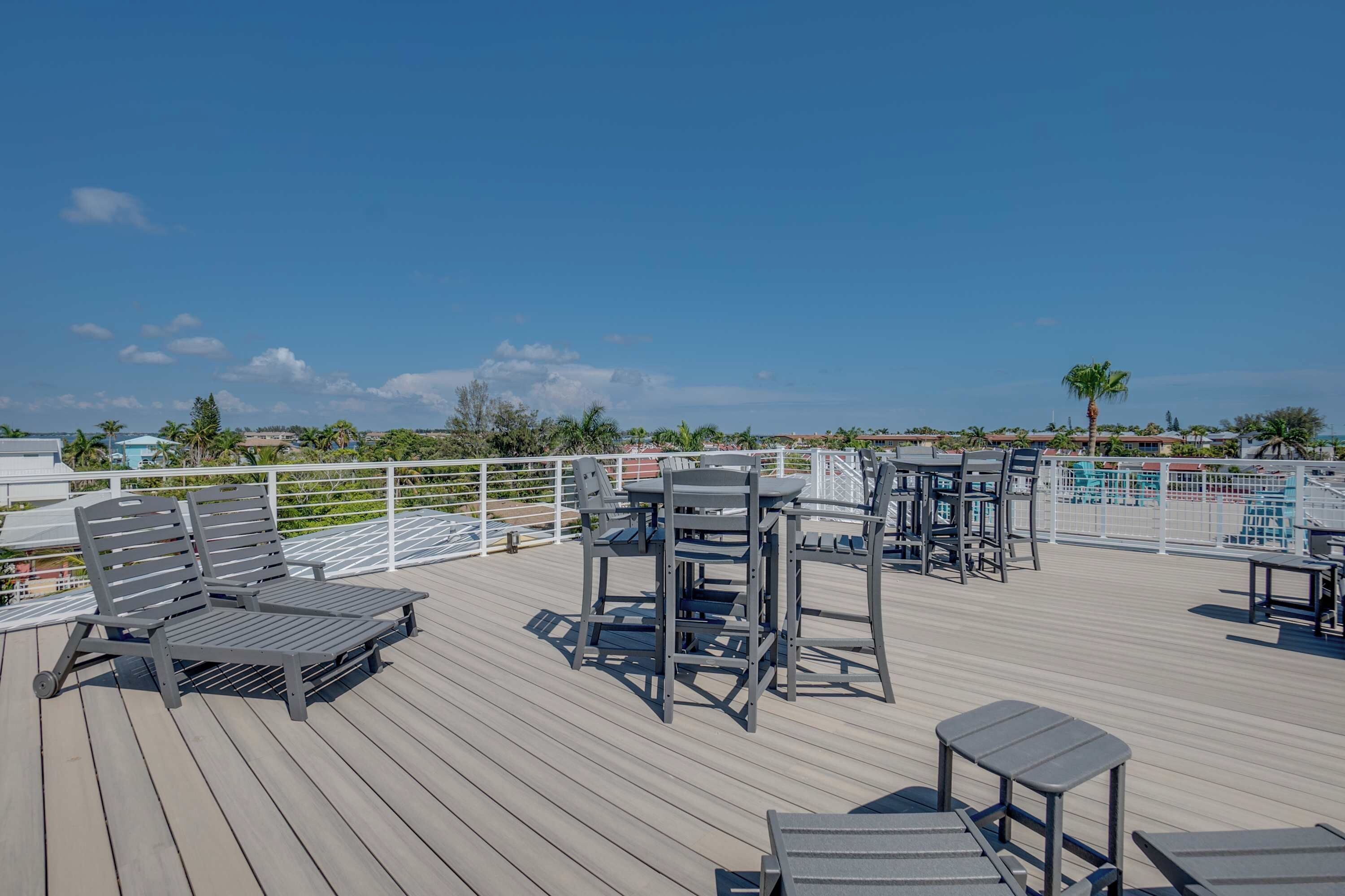 A rooftop deck with outdoor seating and a view of the surrounding landscape.