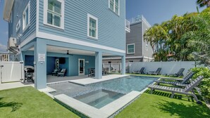 Propiedad residencial con piscina, zona de estar exterior y porche cubierto.