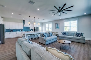 A modern kitchen with white cabinets, a blue backsplash, and a central island. - Endless Summer (Bradenton Beach)