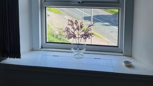 A window with a view of a tall building and a parking lot. - Private Parking, Urban Comfort & City Haven (Plymouth)