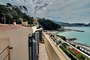 Een balkon met uitzicht op een kustgebied, inclusief een pier en een wateroppervlak.