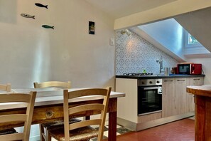 A kitchen with a dining area, a small oven, a microwave, and a skylight. - GuestHost - Comfortable apartment of approximately 64 m2, able to accommodate up to 4 people, located on the fourth floor of a building without a lift. The accommodation is located in an area full of all services and boasts a wonderful view of the San Te (Lerici)