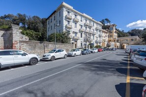 A multi-story building with balconies, parked cars, and a clear sky. - GuestHost - Comfortable apartment of approximately 64 m2, able to accommodate up to 4 people, located on the fourth floor of a building without a lift. The accommodation is located in an area full of all services and boasts a wonderful view of the San Te (Lerici)