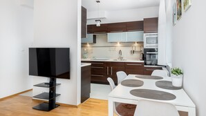 Una cucina moderna con mobili in legno scuro, un piano di lavoro bianco e un forno integrato.