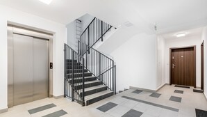 Een modern interieur met een trap, lift en een deur.