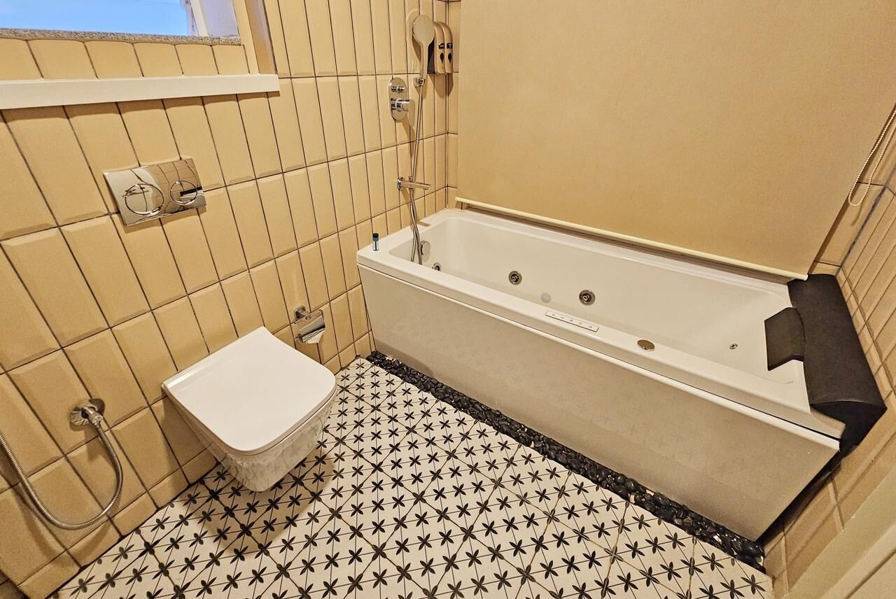 A bathroom with a bathtub, toilet, and shower.