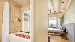 Un baño moderno con bañera, ducha y un ventanal grande.
