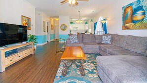 A living room with a television, sofa, coffee table, and ceiling fan. - MP101-Building 22 Magnolia (Myrtle Beach)