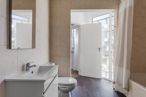 Features a sleek vanity with sink and separate toilet.