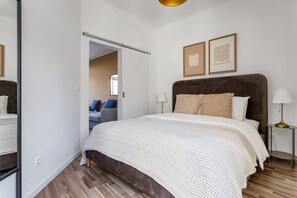 Relax in a spacious room with a large bed, bedside table, and comfortable seating area.