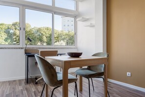 Enjoy meals with a view in this serene dining area, featuring a large window and comfortable seating for two.