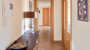 A hallway with a wooden floor, a desk with a lamp, a telephone, and a door leading to another room. - Holidays2Malaga Heroe de Sostoa with pool view (Málaga)