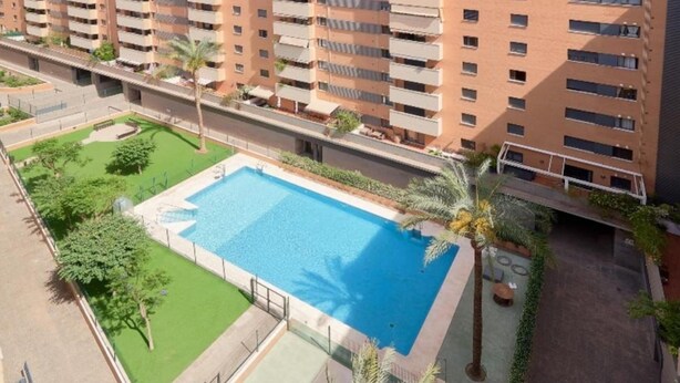 A multi-story residential building with a swimming pool surrounded by greenery. - Holidays2Malaga Heroe de Sostoa with pool view (Málaga)
