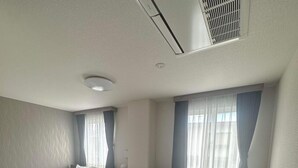 Una habitación de hotel con una cama grande, un escritorio y una ventana con cortinas.