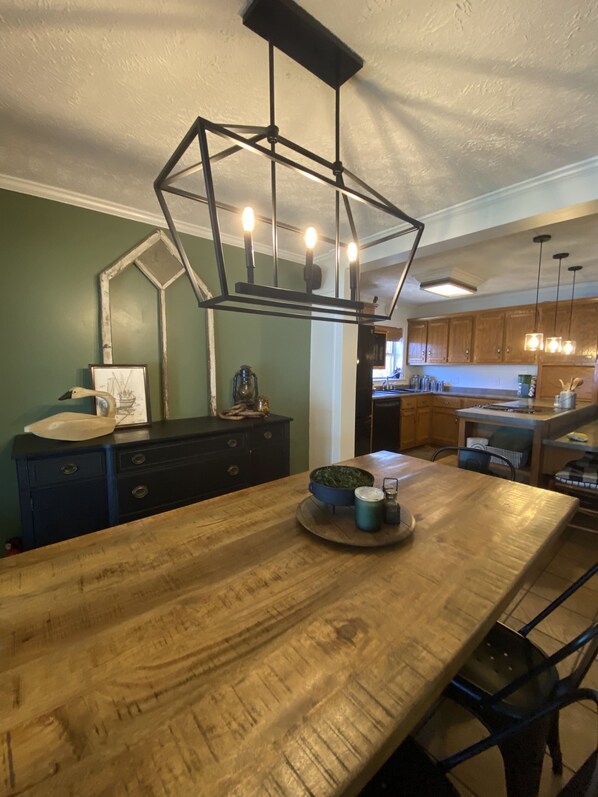 A kitchen with a wooden island, pendant lights, and a view into the dining area. - Hidden Cove, Private Dock, Game Room, Hot Tub (Eva)