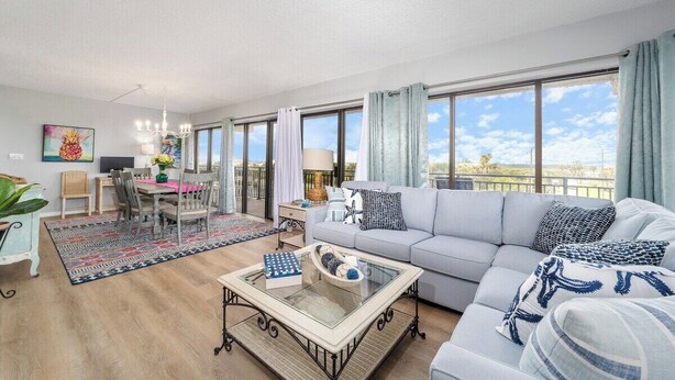 En rummelig stue med sofa, sofabord og spiseplads.
