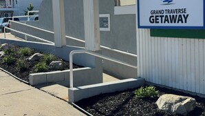 Ein Schild für Grand Traverse Getaway mit einem Logo, das ein Segelboot und eine Sonne zeigt.