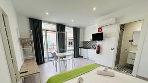 Une chambre d’hôtel équipée d’un lit, d’un bureau, d’une chaise, d’une télévision, d’un extincteur et d’une salle de bain.