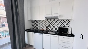 Une cuisine moderne avec des armoires blanches, un comptoir noir et un pare-feu décoré.