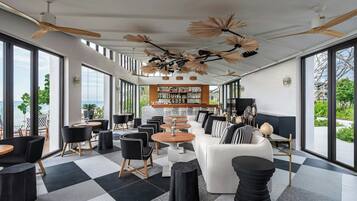 Un interior moderno con piso a cuadros, una zona de bar y amplias ventanas que ofrecen vistas al exterior.