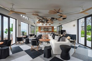 A modern interior with a checkered floor, a bar area, and large windows offering a view of the outdoors. - Khao Lak Marriott Beach Resort and Spa  (Takua Pa)