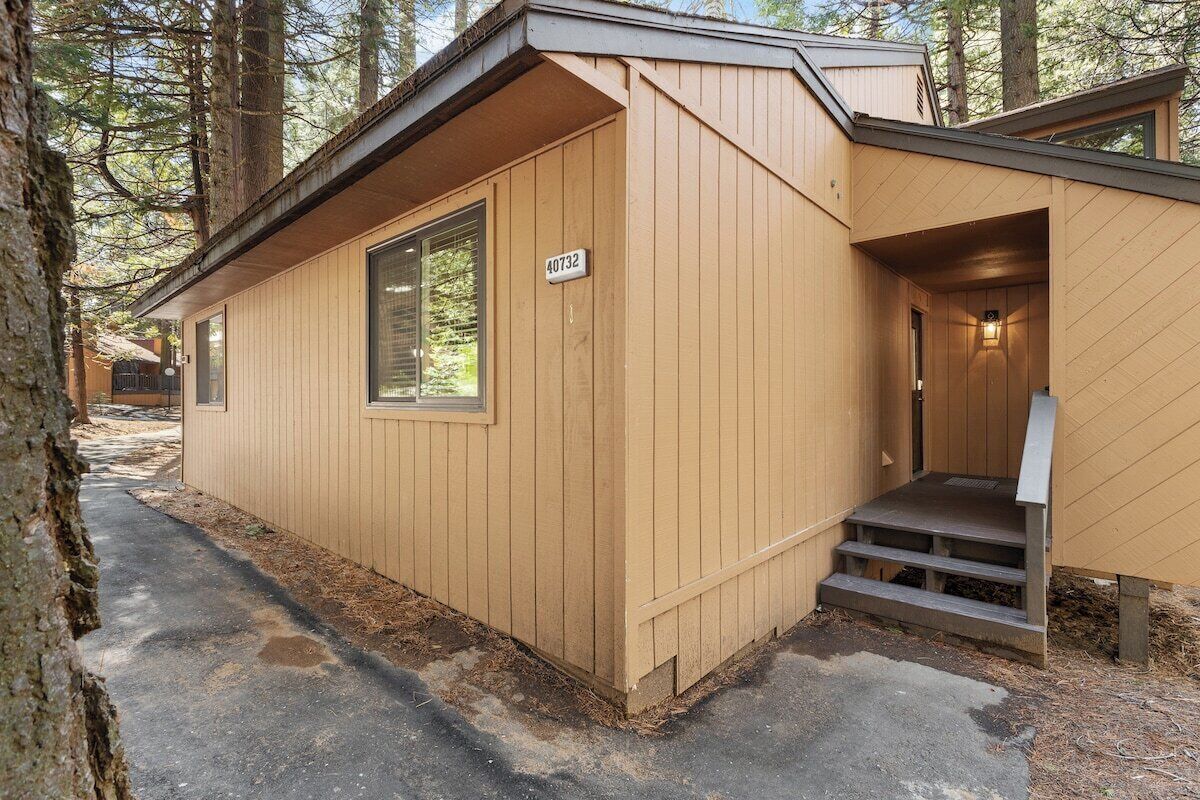 A wooden cabin with a number sign, a window, and a door.