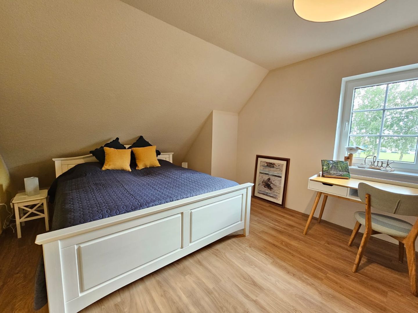 Ein Schlafzimmer mit einem Bett, einem Schreibtisch und einem Fenster.