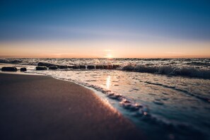 A beach scene with waves and a sunset.