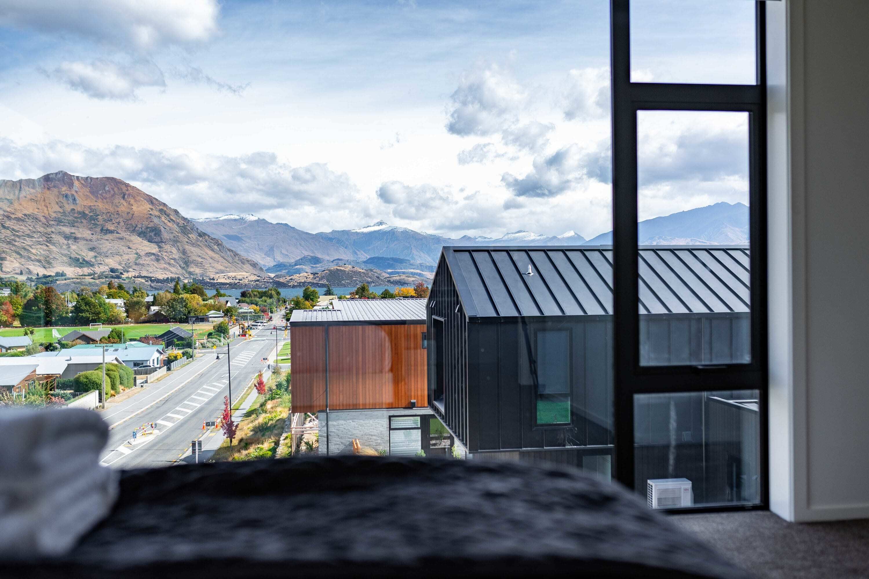 A modern building with large windows overlooking a valley and mountains.