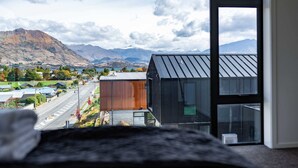 A modern building with large windows overlooking a valley and mountains. - Grand Alpine Vista Escape (Wanaka)