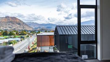 A modern building with large windows overlooking a valley and mountains.