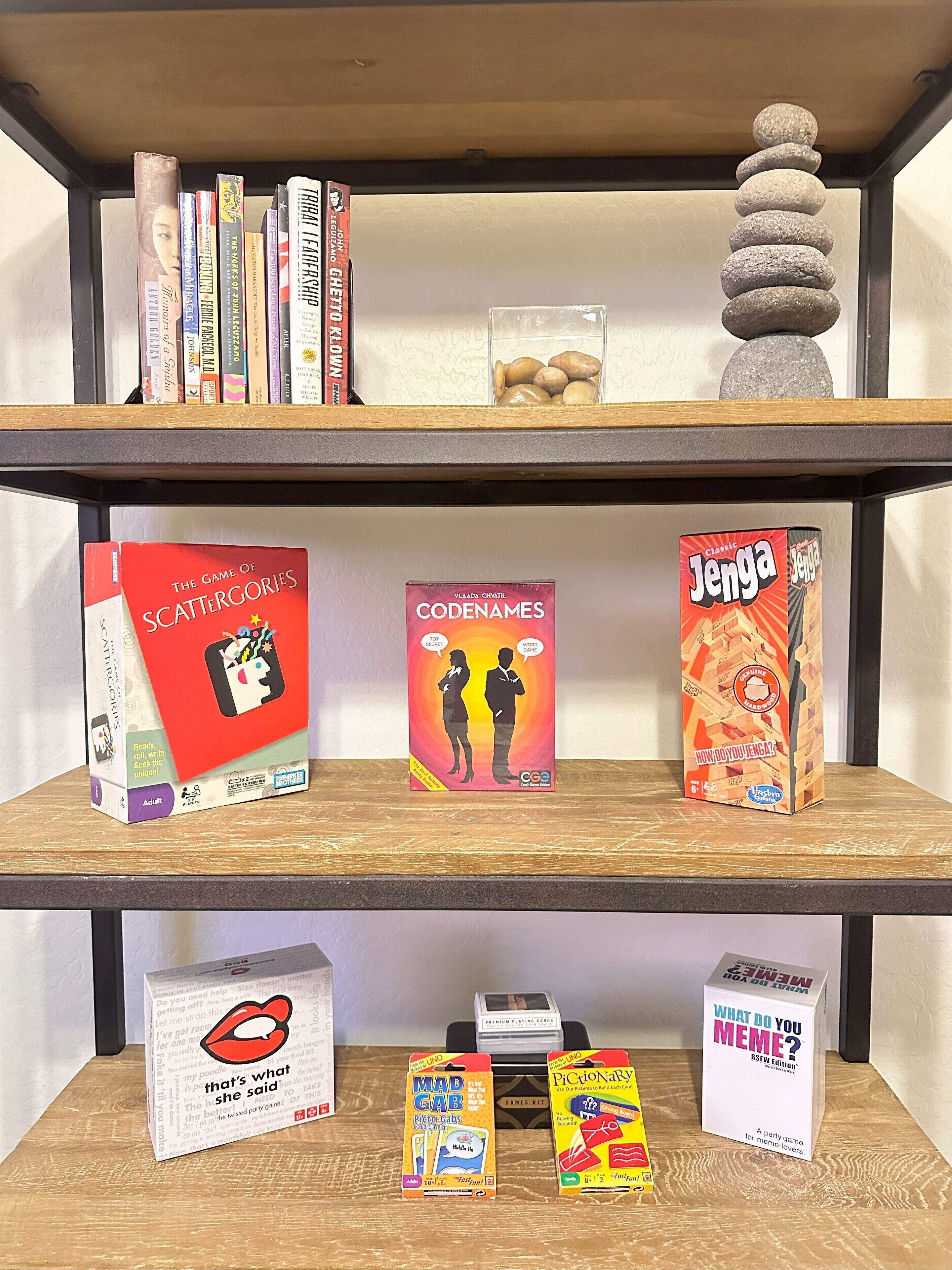 Una estantería con varios juegos de mesa y libros.