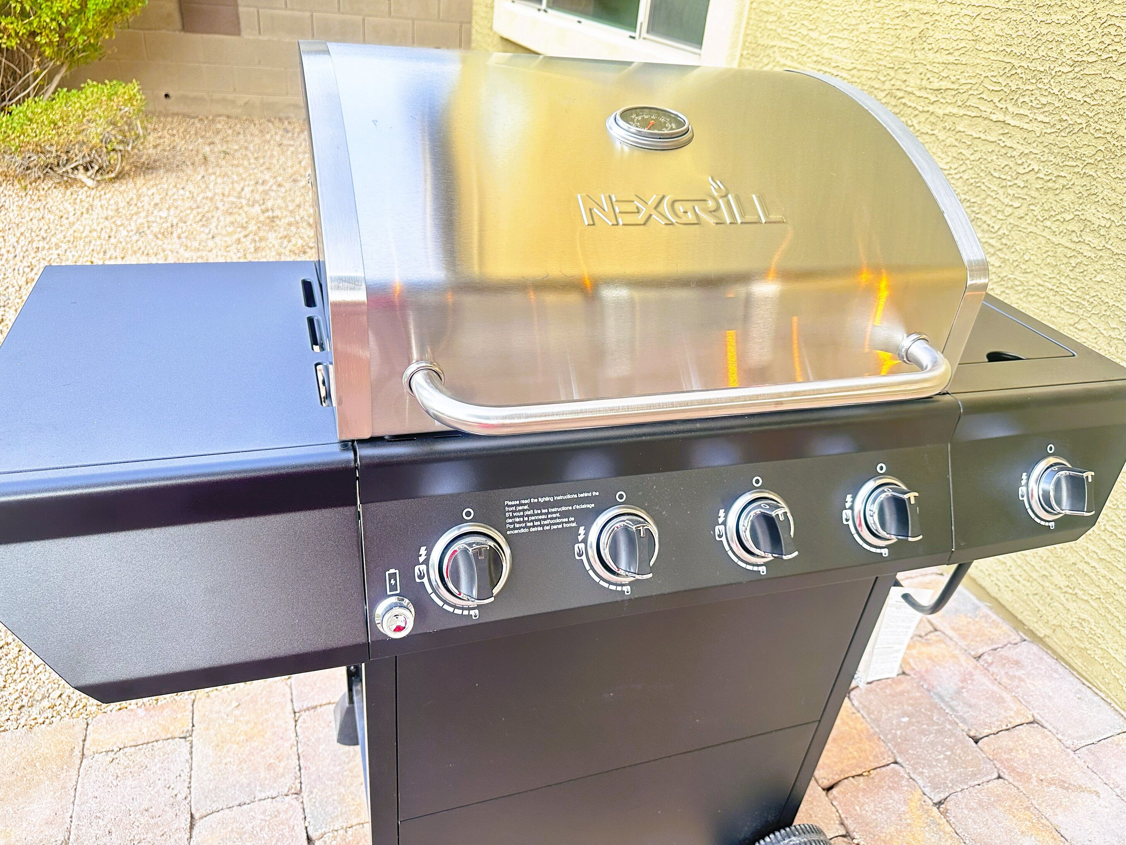 Un barbecue NEXGRILL doté de quatre boutons de contrôle et d’un écran numérique.