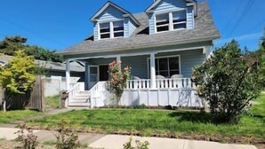 A two-story house with a front porch, a covered entryway, and a small front yard. - Family/Pet Friendly Craftsman (Newberg)